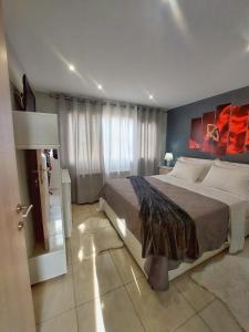海若克利欧MAXIM APARTMENT的一间卧室设有一张大床和一个大窗户
