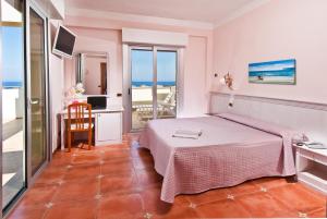 西尼加利亚利昆尔齐酒店的一间带一张床和一张书桌的卧室以及一个阳台