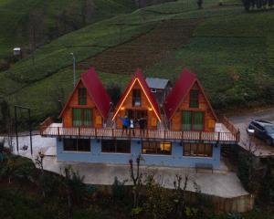 里泽Bungi dağ evleri的一座位于山丘上的大型木房子,设有门廊