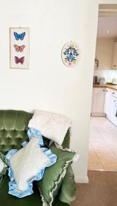 埃文河畔斯特拉特福Traditional 2 bedroom Cottage的一张绿色沙发上摆着一大堆枕头