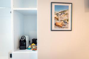 马奥莱MARE LUNA的一间房间,墙上挂着一张照片,配有一个白色衣柜