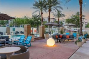 凤凰城菲尼克斯机场雅乐轩酒店的一个带桌椅的庭院,棕榈树