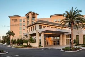 奥兰多SpringHill Suites by Marriott Orlando Theme Parks/Lake Buena Vista的停车场前方的棕榈树建筑