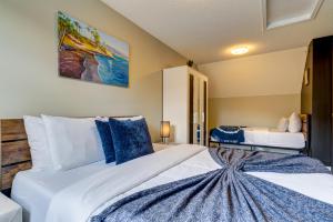 坎莫尔Cozy 1 bedroom Apartment Canmore / Banff的卧室配有带蓝色枕头的大型白色床