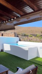 阿格特Casa Notas de Color Y Sal的庭院设有白色长凳和草地。