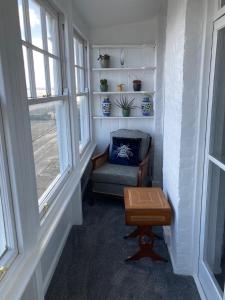 拉姆斯盖特Paragon Home的客房设有椅子、桌子和窗户。
