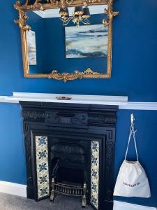 拉姆斯盖特Paragon Home的蓝色的客房设有壁炉和镜子