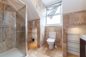 伦敦2 Bedroom Duplex Apartment的一间带卫生间和淋浴的浴室以及窗户。