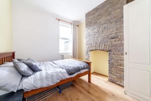伦敦2 Bedroom Duplex Apartment的砖墙房间的一个床位