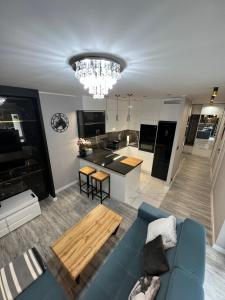 格丁尼亚Black Horse 24h zameldowanie的一间带蓝色沙发的客厅和一间厨房