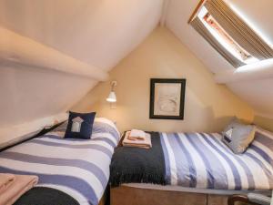 罗宾胡兹贝Delft Cottage的阁楼间设有两张床,设有窗户