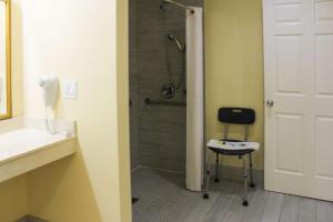 梅德福梅德福旅馆的带淋浴的浴室和椅子