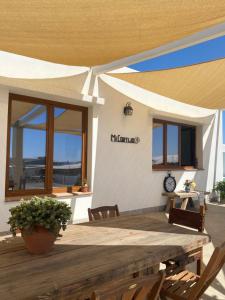 阿尔么丽亚Mi Cortijo hotel de playa的一座带木桌和椅子的庭院和一座建筑