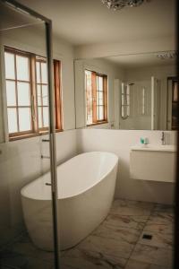 霍巴特奥塔戈住宿加早餐旅馆的浴室配有大型白色浴缸和水槽