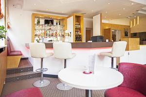 曼海姆埃蒙俾斯麦酒店的酒吧配有白色椅子和白色桌子