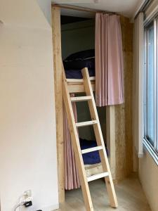 福冈博多1号云共享酒店的客房内的双层床,带梯子