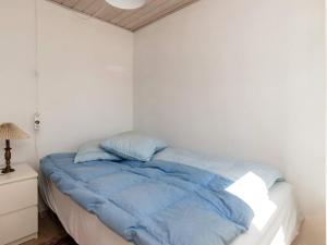 NibeHoliday home Nibe VII的白色客房的一张床铺,配有蓝色棉被