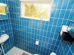霍伊比Holiday home Højby III的蓝色瓷砖浴室设有水槽和窗户