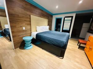 惠蒂尔Casa Blanca Inn & Suites Whittier的一间卧室配有一张床和蓝色凳子