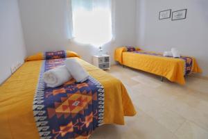 科尔多瓦Albéniz的一间卧室设有两张带黄床单的床和窗户。