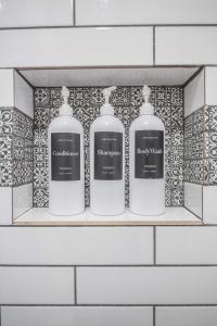 达拉斯Casa Cima的浴室里装有三瓶肥皂的架子