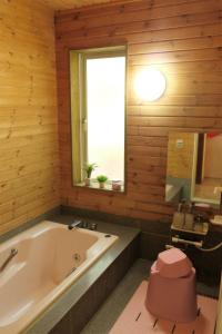 鸣泽市スイートヴィラ 河口湖 Mt.Fuji House的带浴缸的浴室和窗户。