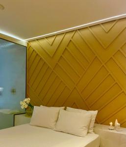 巴西利亚Yolo Motel的一间卧室配有木制床头板和一张带白色枕头的床