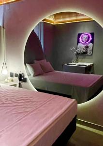 巴西利亚Yolo Motel的一间带两张床的卧室和一间带紫色墙壁的圆形房间