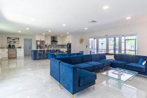 好莱坞Hollywood Paradise Luxury 4BR 3BA Home and Outdoor Fun with Heated Pool的一间带蓝色沙发的客厅和一间厨房