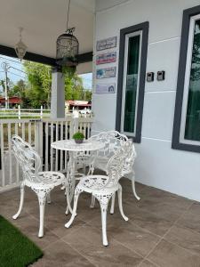 PendangD'LaMar Homestay的庭院里的白色桌椅