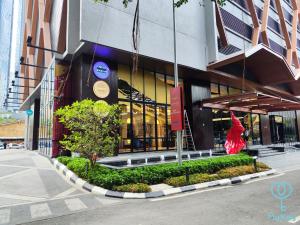 吉隆坡Scarletz Suites KLCC by Mykey Global的一座建筑,前面有一位穿着红色衣服的女人