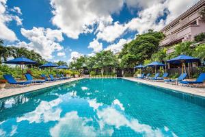 宫古岛汐姬 繁花海湾套房酒店的一个带蓝色椅子和遮阳伞的游泳池