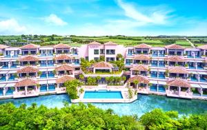 宫古岛汐姬 繁花海湾套房酒店的享有带游泳池的度假村的空中景致