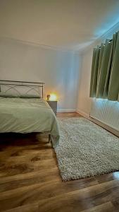 海斯Cozy home in a peaceful area的卧室配有一张床,地板上铺有地毯