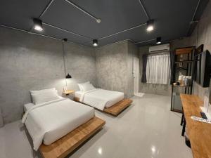 拉廊Loft Space Hotel的一间卧室配有两张床和电视。