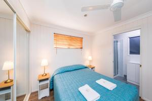 金格罗伊金加罗伊度假村的一间卧室配有一张床,上面有两条毛巾