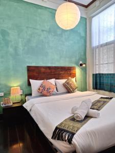 攀牙Thaweesuk Heritage Homestay的一间卧室设有两张床和绿色的墙壁