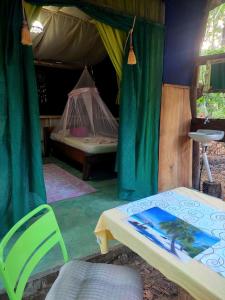 帕克拉Jungle Tent 3x3, Latino Glamping & Tours, Paquera的一间卧室配有带一张床和椅子的帐篷