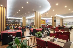 棉兰d'primahotel Kualanamu Medan Formerly Prime Plaza Hotel的一间餐厅,配有红色的桌椅,可满足客人的需求。