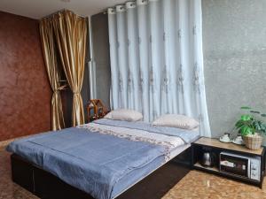合艾The Greenergy - NO ELEVATOR的一间卧室配有一张带蓝色床单和窗帘的床