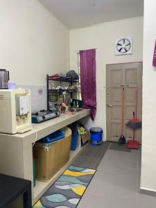 Kampong Alor GajahHomestay Zalida D Musleem的客房设有带柜台和微波炉的厨房。