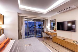 清迈约克提精品酒店的酒店客房配有一张床、一张书桌和一台电视。