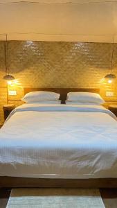 大吉岭Deoja Forest Stay的卧室配有一张带两个枕头的大白色床