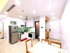 河内Linh Homestay的厨房配有白色橱柜和桌椅
