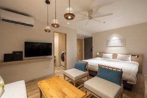 Tsuboyaアルファベットイン那覇国際通りEAST的一间酒店客房,配有一张床和一台电视