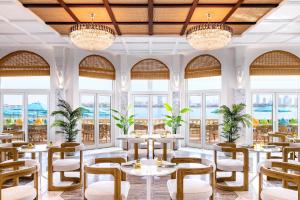 迪拜凯宾斯基棕榈朱梅拉酒店的餐厅设有桌椅和窗户。