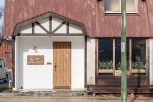 七饭YUKARA LEAF LODGE的一座带木门和窗户的建筑