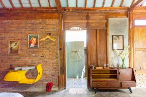 JarakanOmah Dhalang, Ethnic Java House with Nature View的一间卧室设有砖墙和一张黄色的床