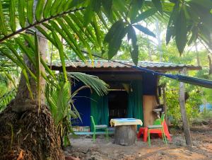 帕克拉Jungle Tent 3x3, Latino Glamping & Tours, Paquera的前面有五颜六色椅子的小房子