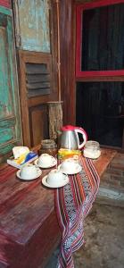 JarakanOmah Dhalang, Ethnic Java House with Nature View的一张桌子,上面有盘子和茶壶